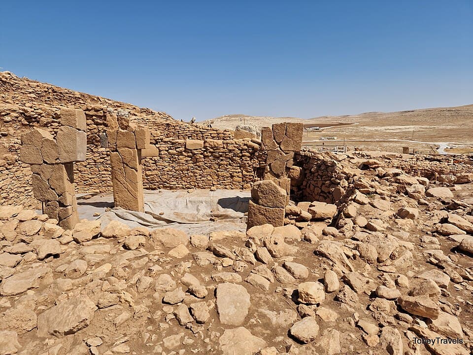 An enclosure at Karahantepe showing T-shaped limestone pillars rising from the carved bedrock floor, with the walls showing the characteristic workmanship of Neolithic construction