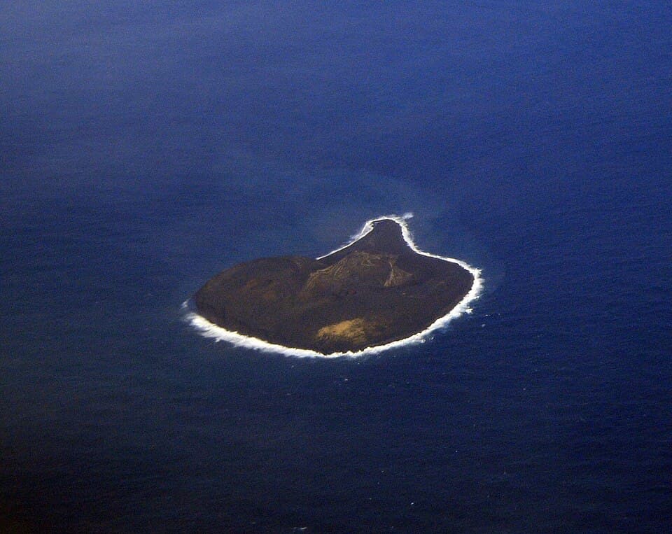 Aerial photograph of Surtsey island showing its dark volcanic landscape surrounded by ocean