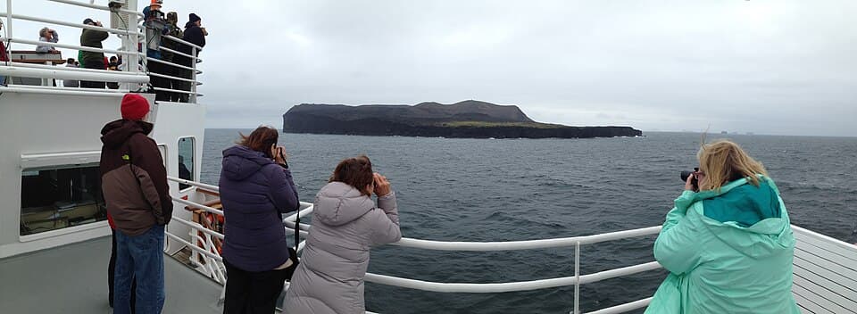 Surtsey island photographed from a boat in 2014, showing dark volcanic coastline