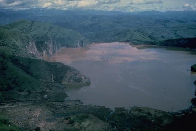 Aerial view of Lake Nyos, a dark crater lake set into the green highlands of northwestern Cameroon.